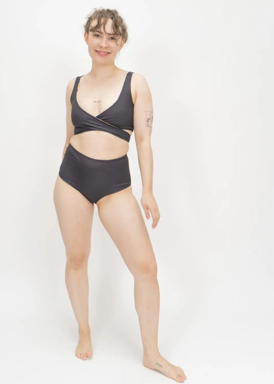 Black two-piece swimsuit with a wrap-style top and high-waisted bottoms.